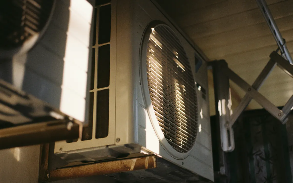 Close-up of the fan grille on an outdoor air conditioning unit in bright sun